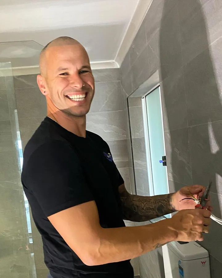 Marcio from Handy Tradie 4 U smiling while working in a newly tiled bathroom