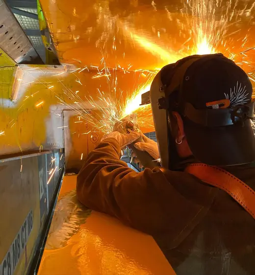 Welder grinding steel in a shower of sparks